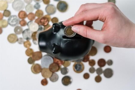 Monedas apiladas junto a documentos de ahorro