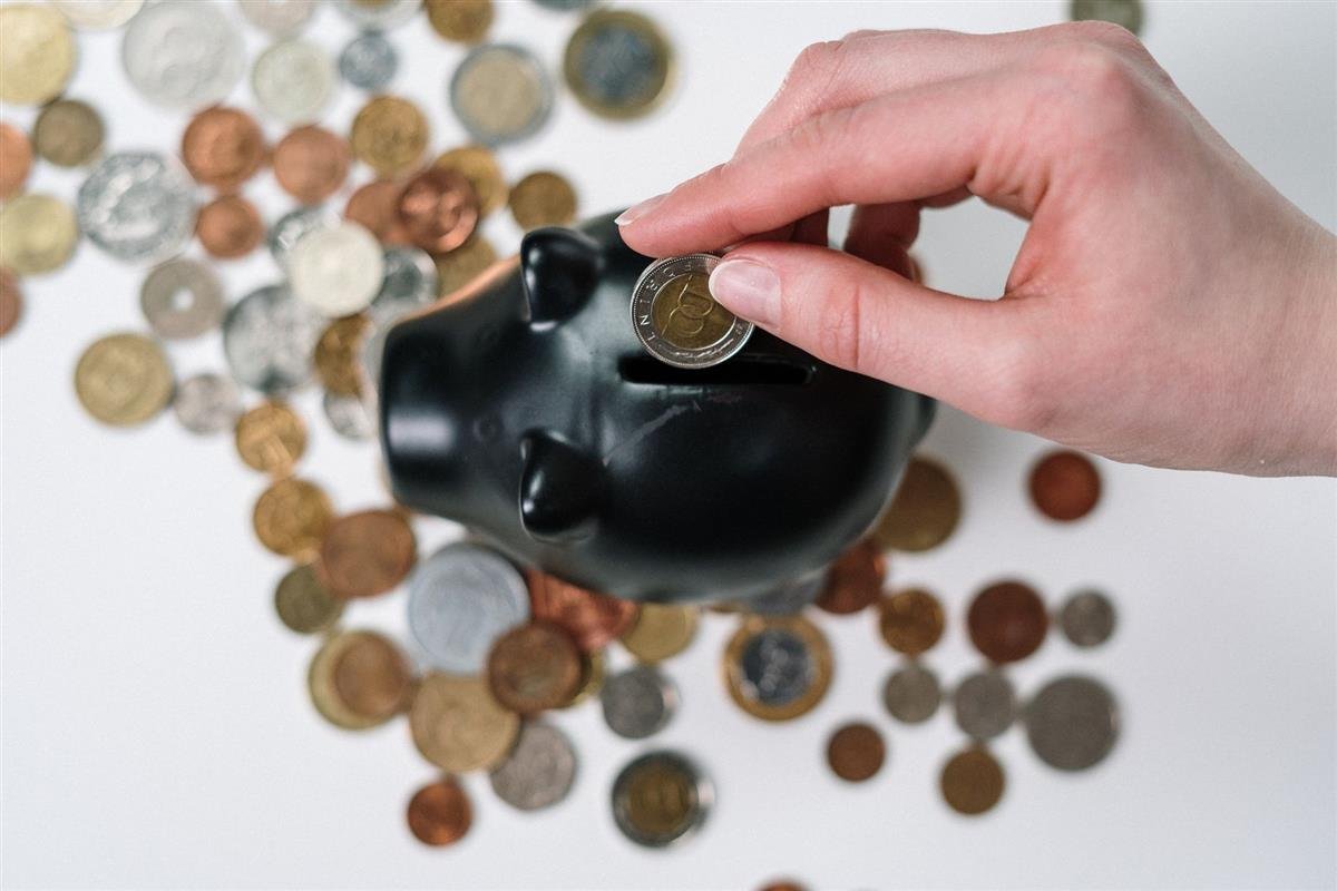 Monedas apiladas junto a documentos de ahorro